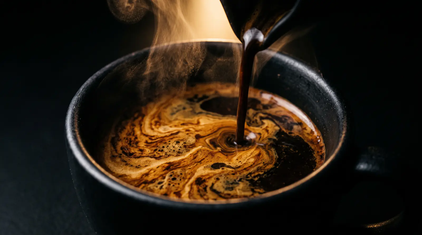 Café recién hecho cayendo en una taza negra con la crema dorada en remolino